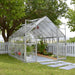 8 x 12 Balance greenhouse installed outdoors in a backyard garden with raised beds and paved entry