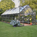 Balance 8 x 20 greenhouse installed in a backyard garden with plants growing inside