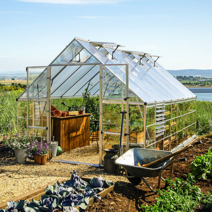 10 × 16 walk-in greenhouse set up in a backyard garden