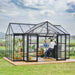 People relaxing inside Triomphe garden chalet greenhouse with seating and plants