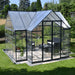 Large cathedral-style Victory greenhouse set on concrete base in backyard garden
